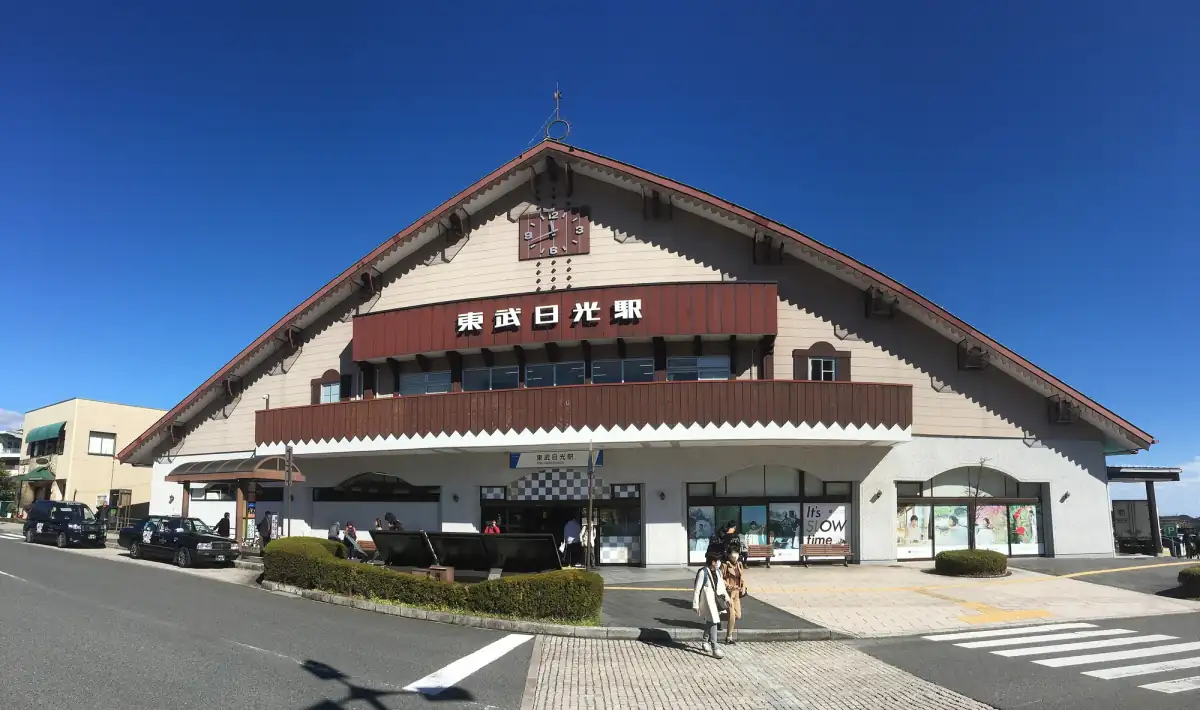 Tobu-Nikko Station building with its red-brown roof under a blue sky