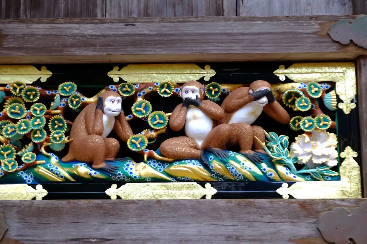 Painted wooden carving of the Three Wise Monkeys covering eyes, ears and mouth at Nikko Toshogu